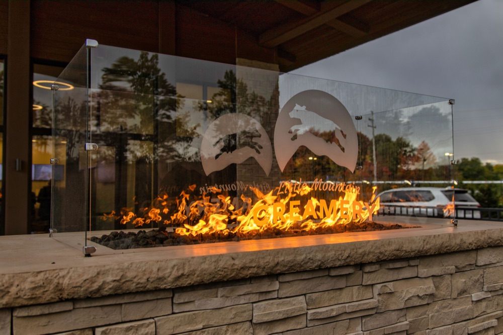 Little Mountain Creamery fire pit and logo at dusk