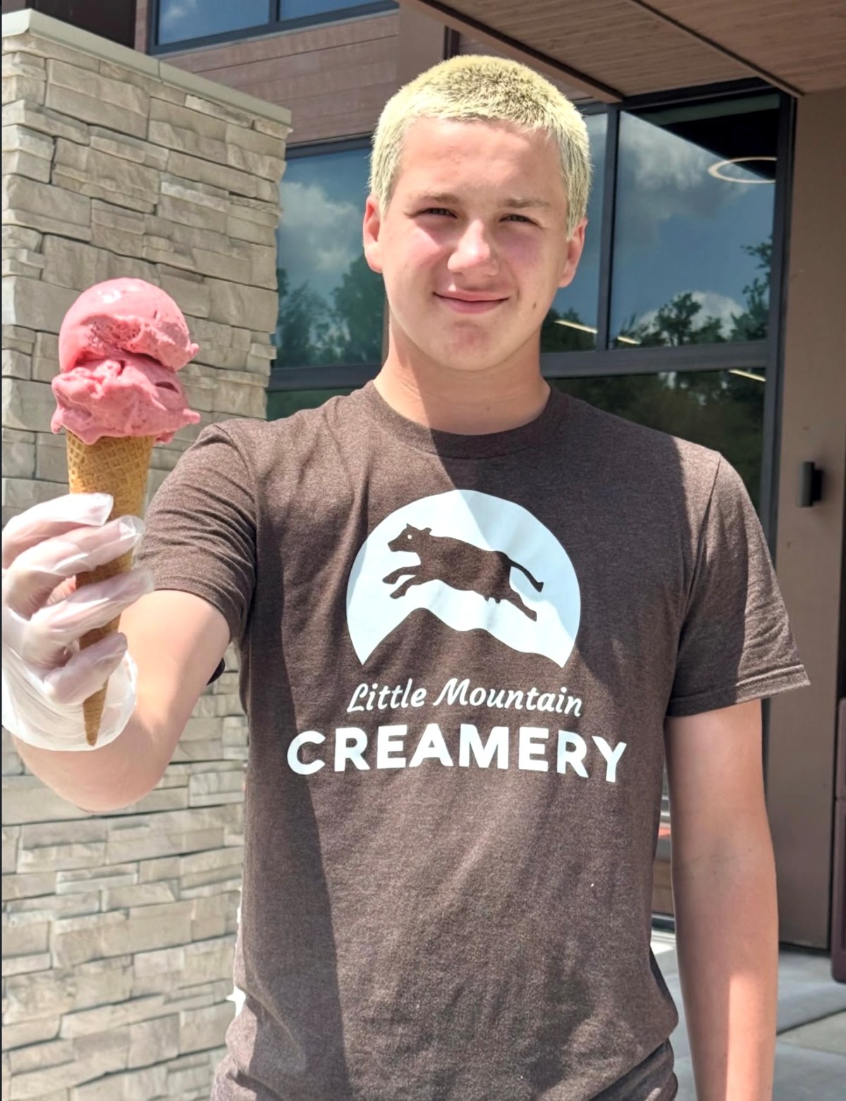 Little Mountain Creamery team member holding a gelato cone outside the shop